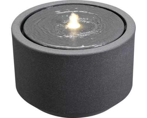 Runder Zimmerbrunnen aus Stein mit Wasser und Licht