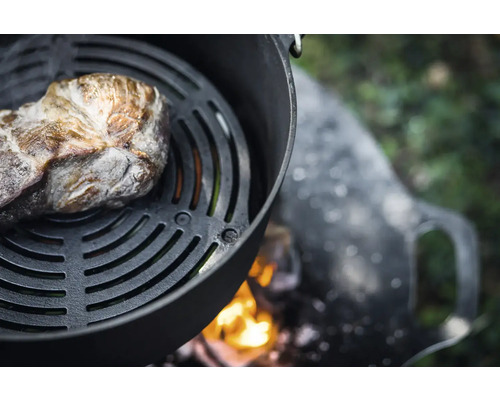 Fleischstück auf Grillrost über offener Feuerstelle