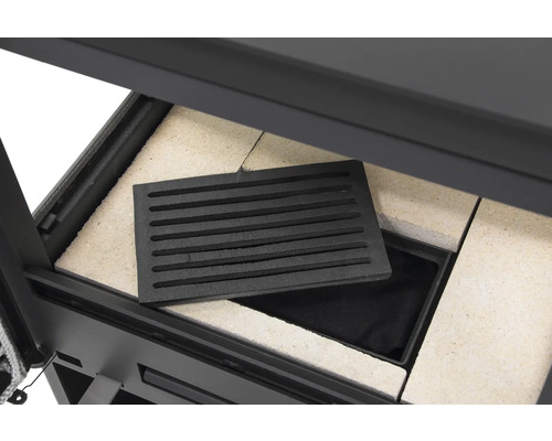 Detailansicht eines Kaminofens mit Feuerraumauskleidung und Gussrost