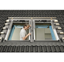 Dachdecker montiert Dachfenster im Ziegeldach.