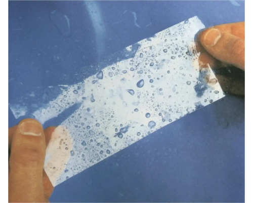 Eine transparente Folie wird mit Wasser benetzt.