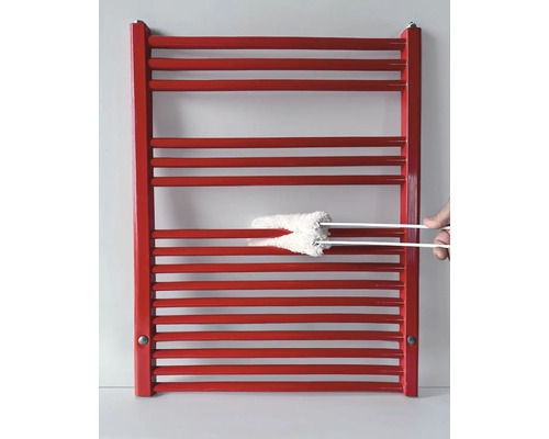 Reinigung einer roten Heizung mit Heizkörperbürste