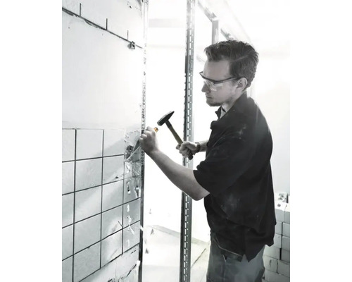 Handwerker entfernt Fliesen mit Hammer und Meißel