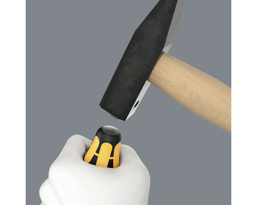 Hand hält Daumenschutz unter Hammer