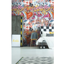 Ein Schlafzimmer mit Graffiti-Tapete, Bett, Stuhl und Dekorationen.