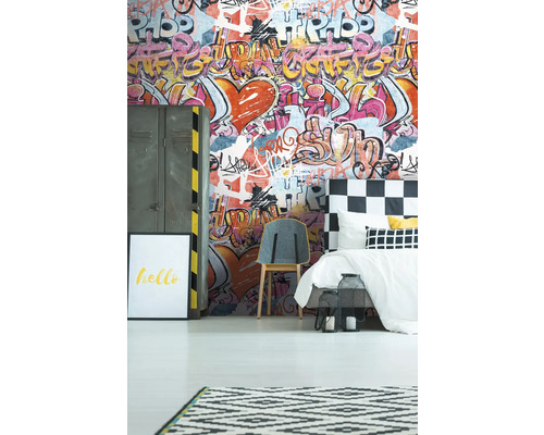Ein Schlafzimmer mit Graffiti-Tapete, Bett, Stuhl und Dekorationen.