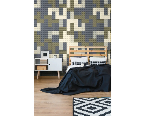 Schlafzimmer mit Wandgestaltung in Form von Bauklötzen, Bett mit Holzrahmen und weißem Nachttisch