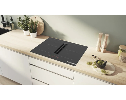 Schwarzes Induktionskochfeld mit integriertem Dunstabzug in einer Küchenzeile.