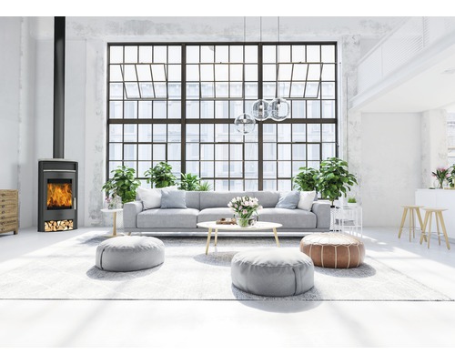 Wohnzimmer mit Kaminofen, Sofa und großen Fenstern für eine helle und freundliche Atmosphäre.