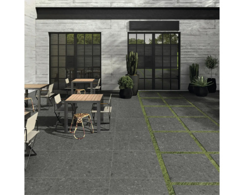 Außenbereich mit Terrassenplatten, Tischen, Stühlen und Pflanzen