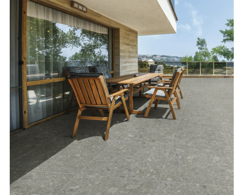 Terrasse mit grauen Bodenfliesen und Holzmöbeln