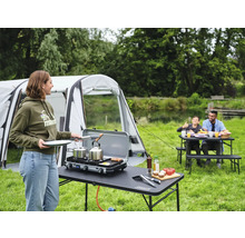 Camping Szene mit Zelt, Tisch, Gasgrill und Familie beim Essen im Freien