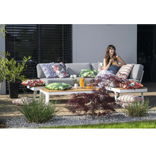 Terrassenszene mit grauer Loungegarnitur, Couchtisch und dekorativen Kissen auf einer Terrasse