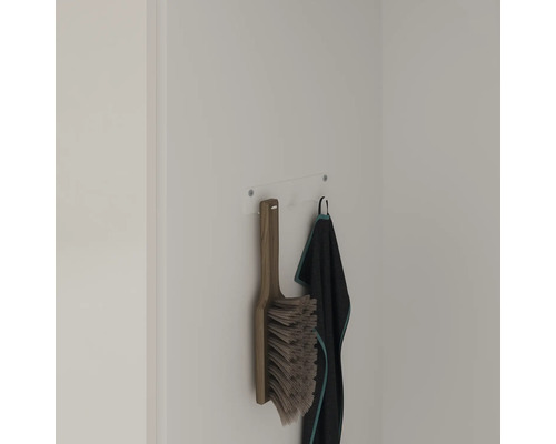 Bürste mit Holzgriff und Textilhandtuch an einer Wandhängevorrichtung