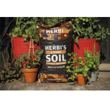 Sack Herbi''s Living Soil gebrauchsfertige Erdmischung zwischen bepflanzten Blumentöpfen