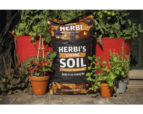 Sack Herbi''s Living Soil gebrauchsfertige Erdmischung zwischen bepflanzten Blumentöpfen