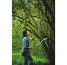 Frau benutzt eine Astschere im Garten, um Äste zu schneiden