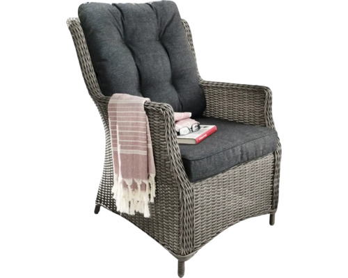 Geflochtener Sessel mit Kissen, Buch und Tuch