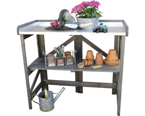 Gartentisch aus Holz mit Pflanzen, Töpfen und Gartengeräten