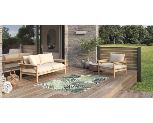 Terrasse mit Holzmöbeln und Teppich mit Blattmuster