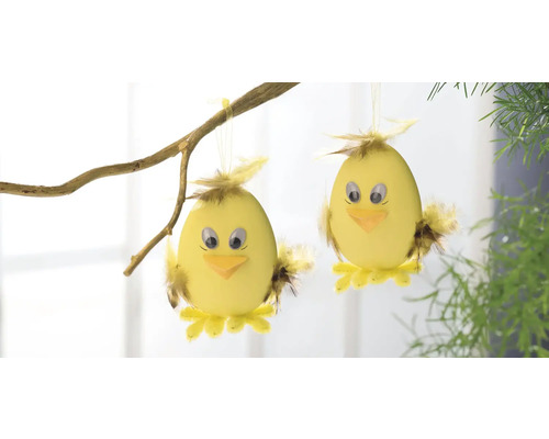 Zwei gelbe Osterküken als Dekoration an einem Zweig