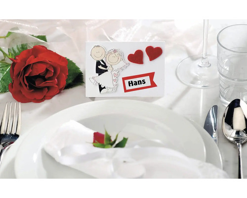 Dekorativer Hochzeitstisch mit Namensschild, Geschirr und Rose