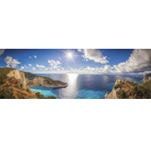 Panoramaaufnahme einer Küstenlandschaft mit Meerblick unter blauem Himmel mit Wolken und Sonnenschein