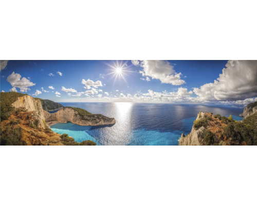 Panoramaaufnahme einer Küstenlandschaft mit Meerblick unter blauem Himmel mit Wolken und Sonnenschein