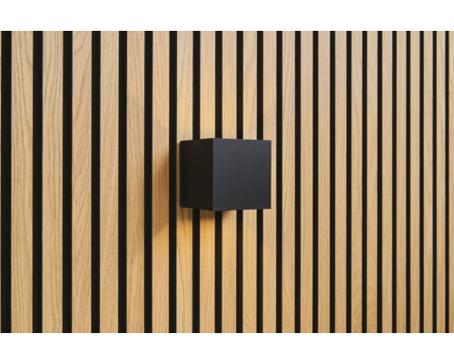 Wandleuchte in Würfelform an Holzpaneelwand