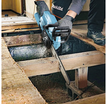 Handwerker sägt mit einer Akku-Kettensäge ein Holzbrett. Makita Logo.