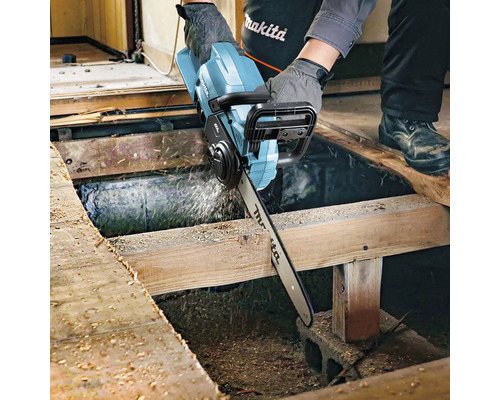 Handwerker sägt mit einer Akku-Kettensäge ein Holzbrett. Makita Logo.
