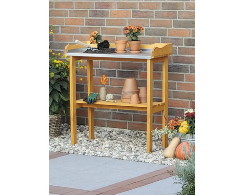 Gartentisch mit Arbeitsfläche aus Metall, Ablage und Gartenzubehör.