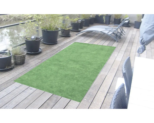 Grüner Kunstrasen auf einer Holzterrasse mit Pflanzgefäßen und Liegestuhl.