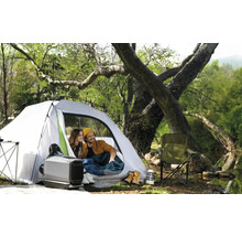 Szene mit Campingplatz, Zelt, Campingheizung und zwei Personen