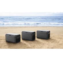 Drei Kühlboxen am Strand vor dem Meer.