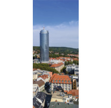 Ansicht eines Stadtbilds mit Hochhaus, Wohnhäusern und bewaldeten Hügeln