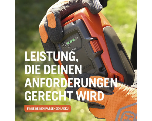 Husqvarna Akku wird von einer Person mit Arbeitshandschuhen gehalten