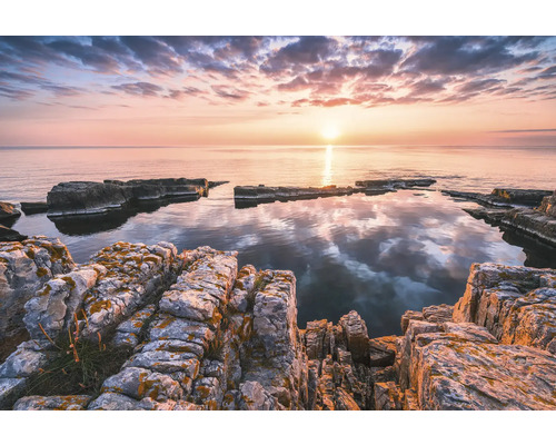 Felsige Küstenlandschaft bei Sonnenaufgang mit ruhigem Wasser