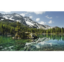 Bergsee mit Bäumen und schneebedeckten Bergen im Hintergrund