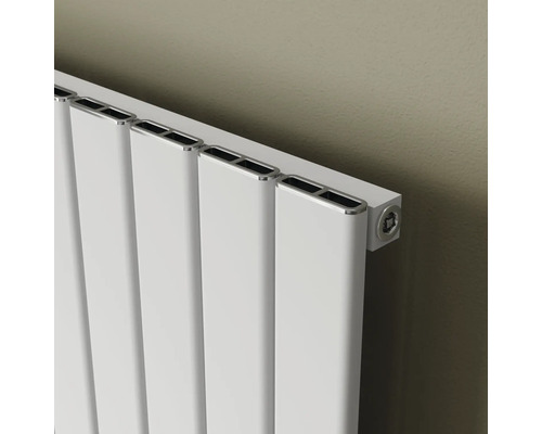 Weißer Heizkörper mit vertikalen Paneelen an einer Wand