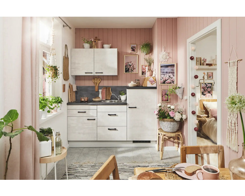 PICCANTE Plus Küchenzeile mit Geräten Casual 180 cm beton weißgrau matt vormontiert Variante rechts 4067368019583 Helle Küche mit weißen Schränken, Arbeitsplatte in Steinoptik und rosa Wandgestaltung für eine freundliche Atmosphäre.