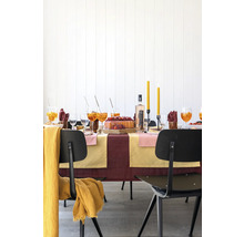 Festlich gedeckter Tisch mit Getränken, Kuchen, Kerzen und Stühlen für eine Feier.