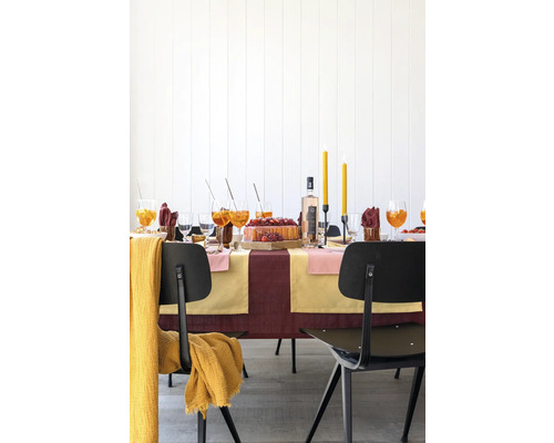 Festlich gedeckter Tisch mit Getränken, Kuchen, Kerzen und Stühlen für eine Feier.