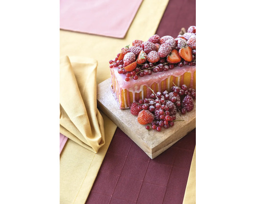 Kuchen mit Guss und Beeren auf einem Holzbrett