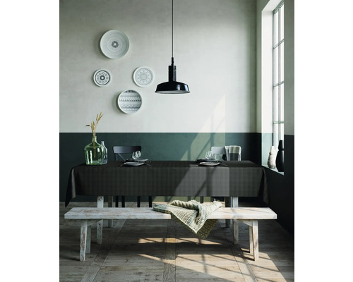 Esstisch mit Tischdecke, Geschirr und Dekoration in einem hellen Raum.