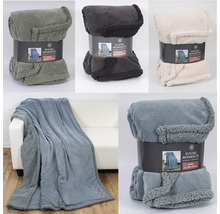 Mehrere Kuscheldecken in verschiedenen Farben, teilweise verpackt, teilweise auf einem Sofa drapiert.