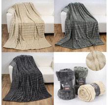 Verschiedene Ansichten von Fleecedecken auf einem Sofa und zusammengerollt