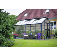 Gewächshaus im Garten mit Gartenmöbeln und Pflanzen
