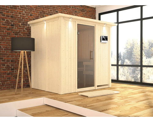 Plug & Play Sauna Karibu Wanja inkl. 3,6 kW Bio Ofen u.ext.Steuerung mit Dachkranz und graphitfarbeneer Ganzglastüre Holzsauna mit Glastür, Innenbeleuchtung und digitalem Bedienfeld in einem hellen Raum