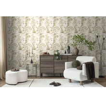 Wohnzimmer mit gemusterter Tapete, Sessel und Kommode für ein stilvolles Ambiente